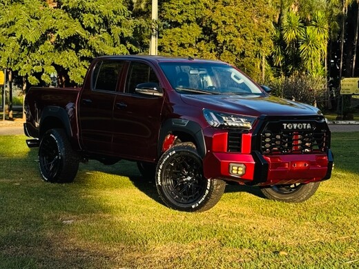 Toyota Hilux vermelho rubi com kit Tundra e rodas pretas aro 20 - Vista dianteira e lateral